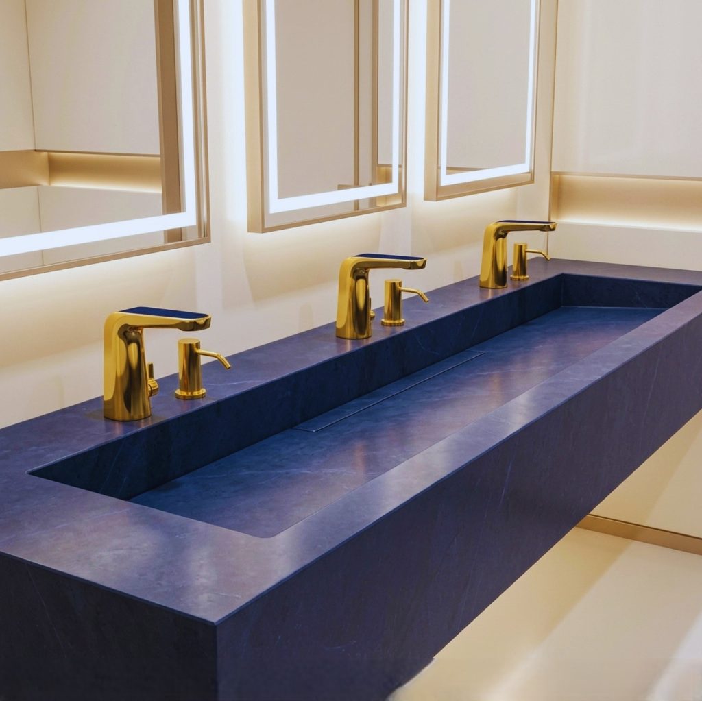 Gold single hole bathroom faucet coordinated with a contemporary sink and clean vanity surface